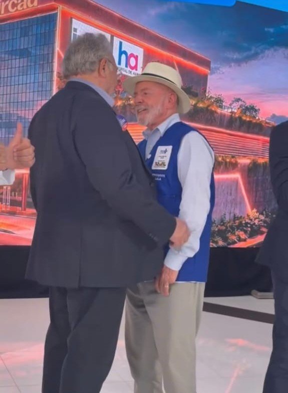 Mussa Calil cumprimenta o presidente Lula, com o telão do Hospital de Amor ao fundo